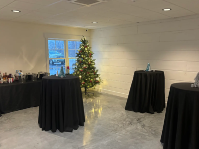 Cocktail reception high-top tables set around an illuminated Christmas tree for a holiday corporate gathering
