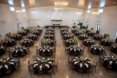 Overhead view of the grand reception hall at The Willow with black round tables and monogram lighting