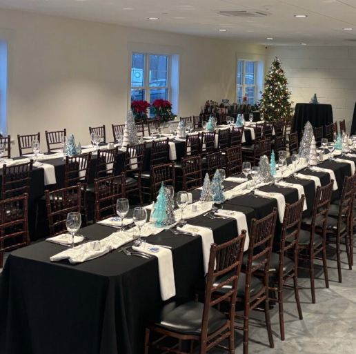 Side room styled with long banquet tables and elegant black linens at The Willow