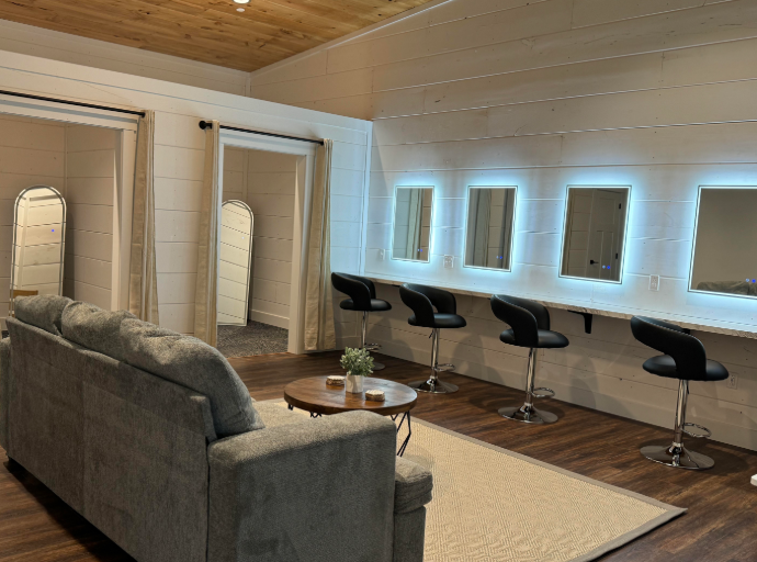 Bridal suite vanity with backlit mirrors, salon swivel chairs, comfortable lounge seating, and private dressing rooms at The Willow