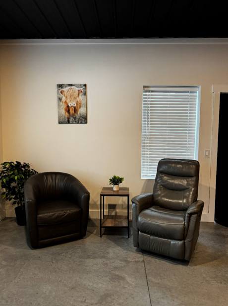 Groom's den seating area with leather recliner and club chairs at The Willow