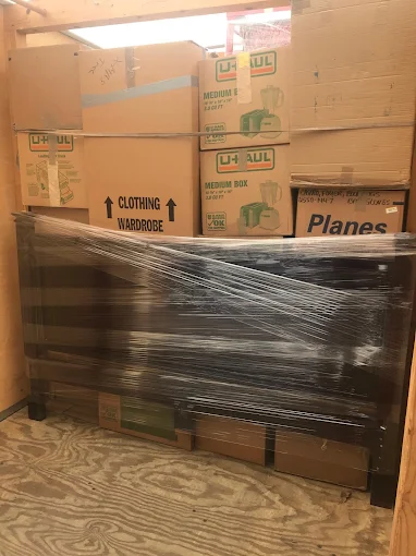 Storage container packed tight with boxes and shrink-wrapped furniture
