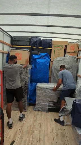 The Moving Guy team carefully loading and securing furniture and boxes inside a moving truck