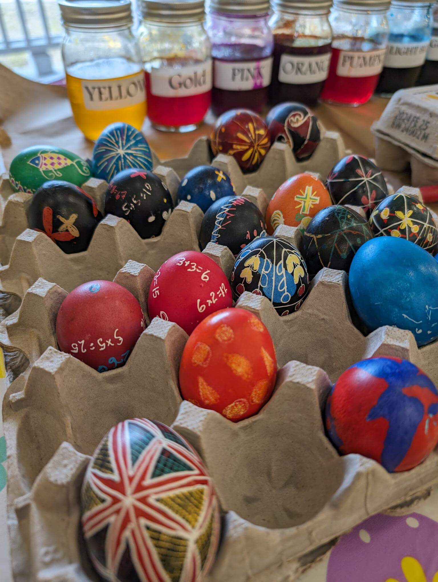 Carton rempli d'œufs pysanky décorés aux motifs traditionnels et géométriques