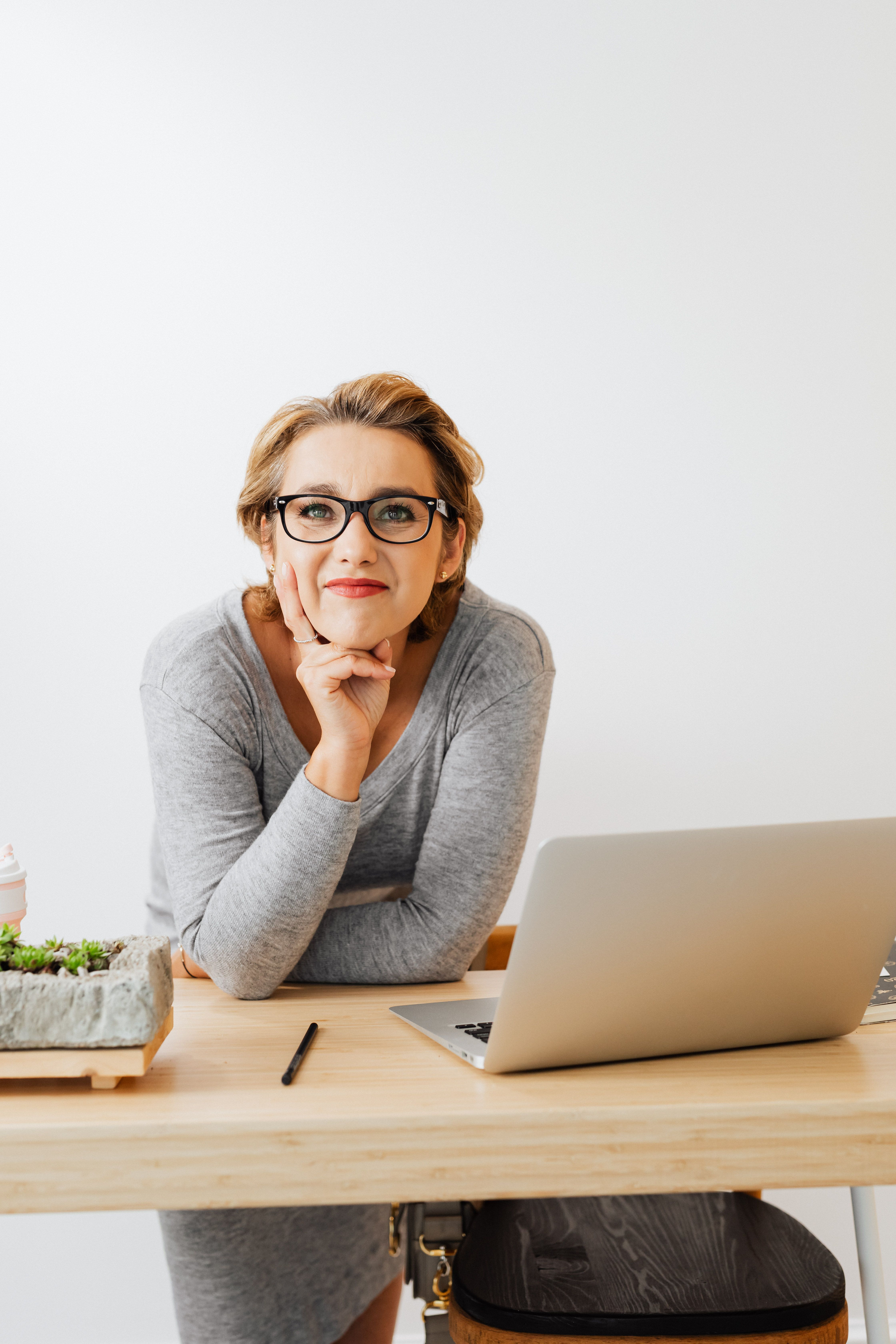 Professional woman leaning forward at her desk, calm and confident