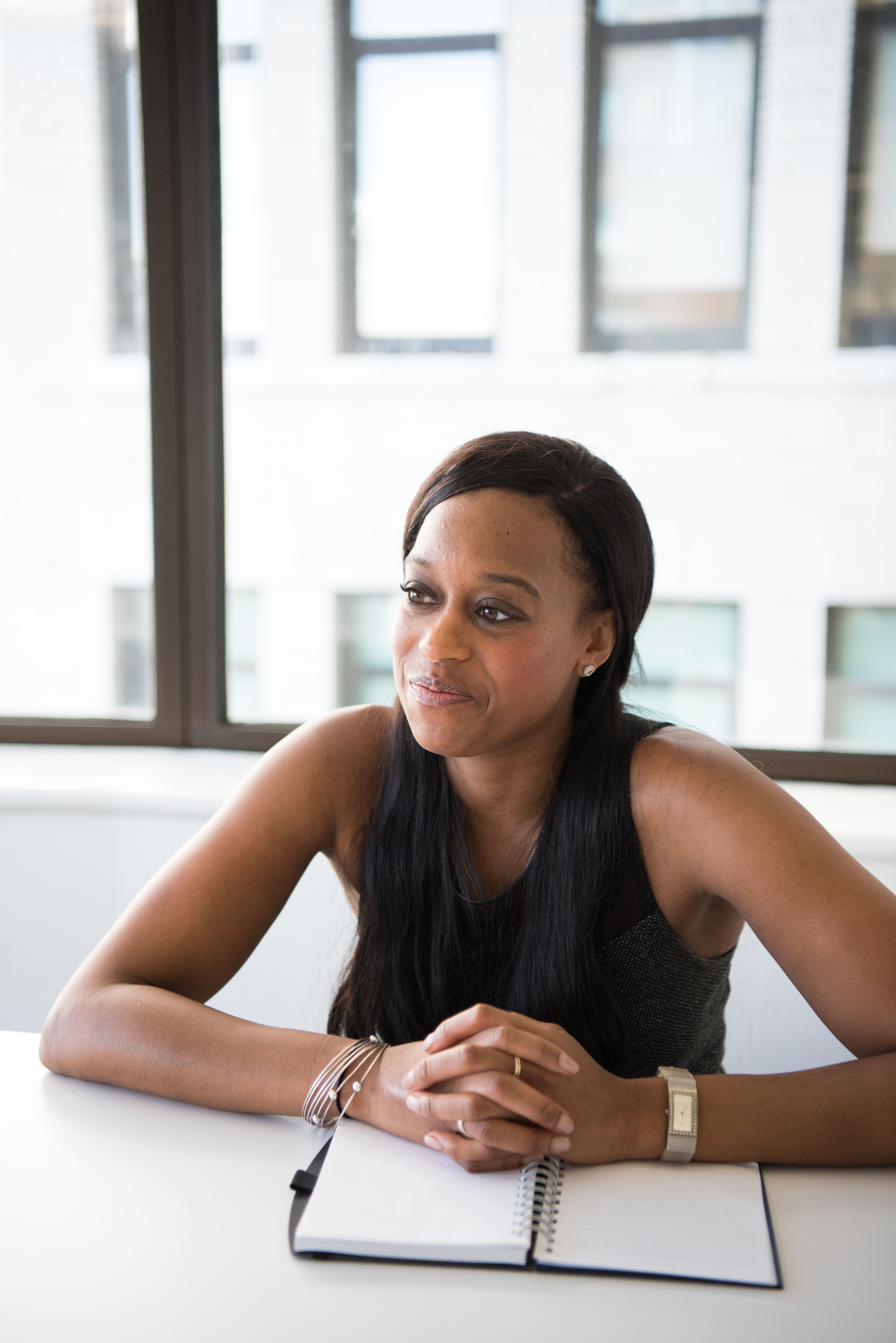 Executive woman smiling with calm focus and a notebook in front of her