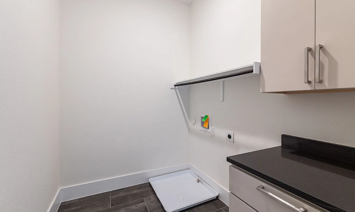 Dedicated laundry and utility room with custom storage and folding counter
