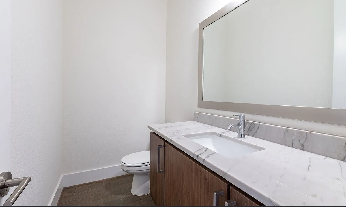Contemporary designer half bathroom with marble vanity and modern finishes