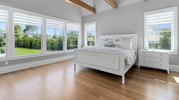 Primary bedroom with vaulted ceiling, exposed beam and white oak flooring in a Hamptons home renovation