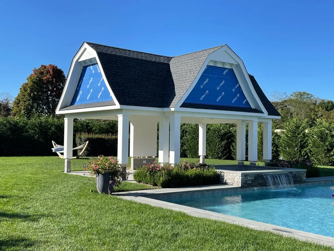 A poolside accessory structure under construction, with the roof, columns and trim complete