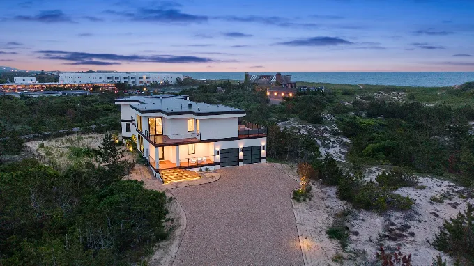 Aerial view at dusk of a contemporary oceanfront home on the East End of Long Island built by Custom Island Homes