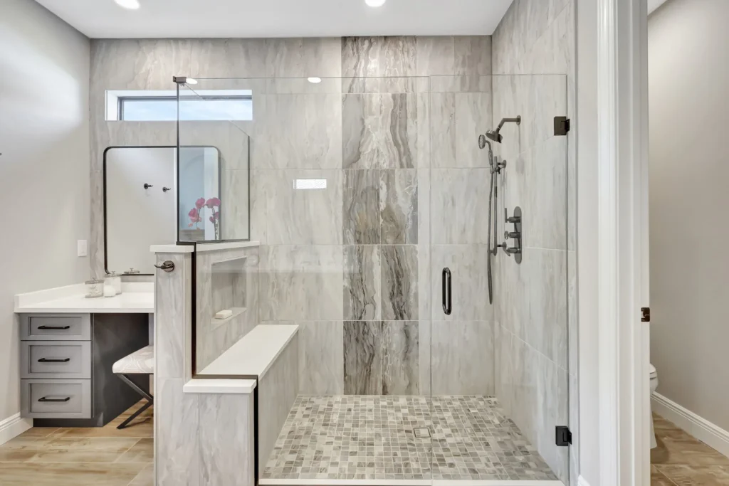 Walk-in shower remodel with frameless glass and stone-look tile by Stuart Kitchen Bath and Flooring