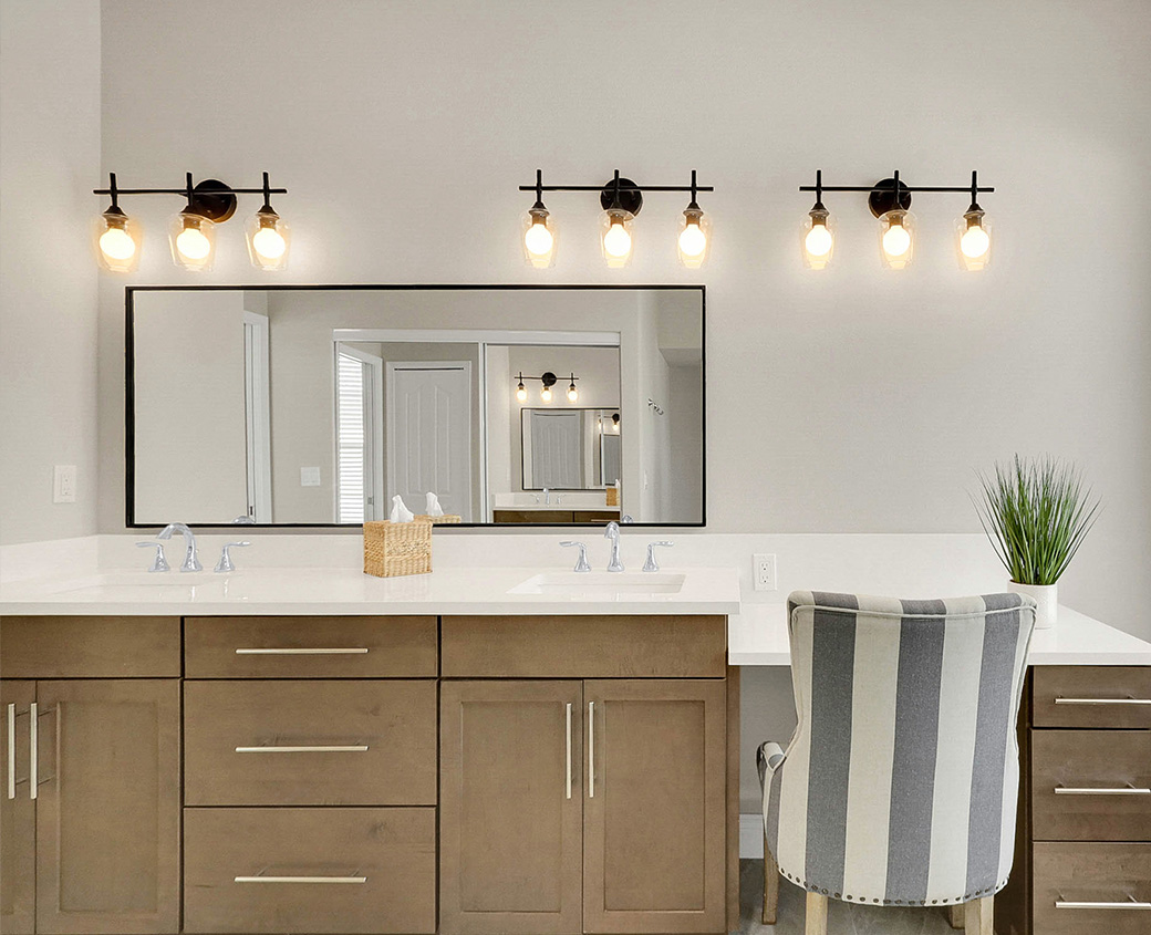 The same primary bathroom after renovation, with custom shaker cabinetry, a quartz countertop and a framed mirror