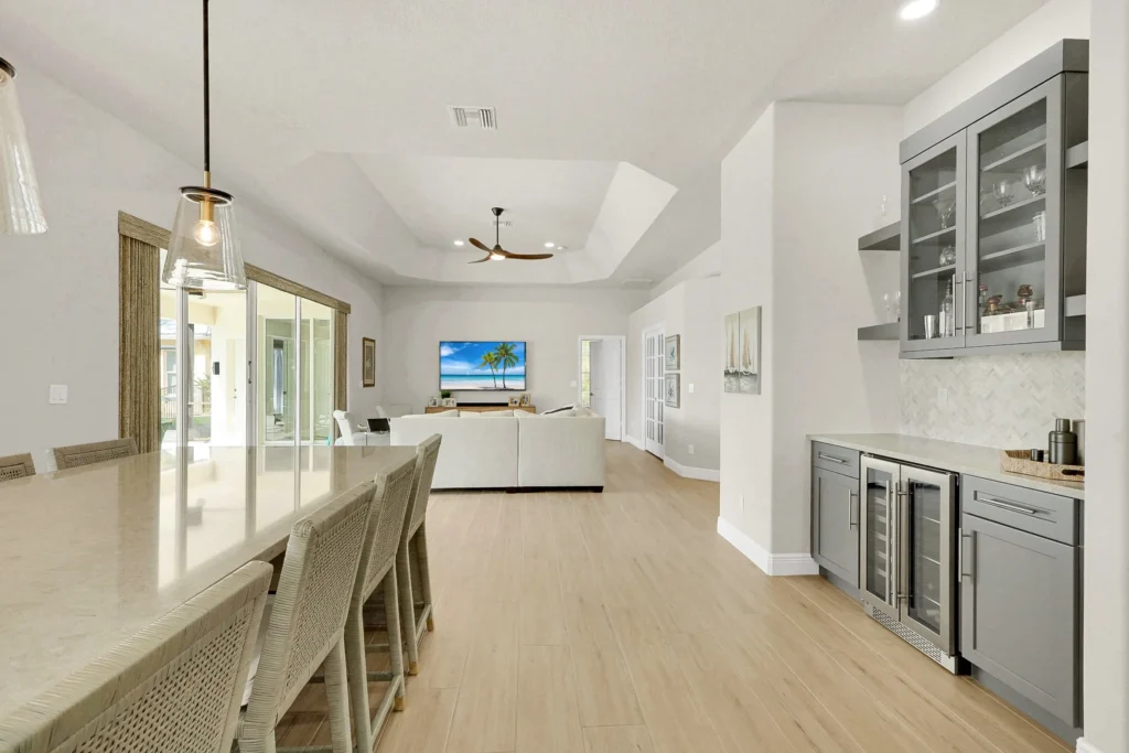 Open-concept home remodel with a grey dry bar and wood-look tile flooring by Stuart Kitchen Bath and Flooring
