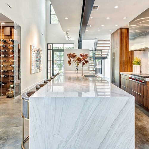 Modern kitchen remodel with a marble waterfall island by Stuart Kitchen Bath and Flooring