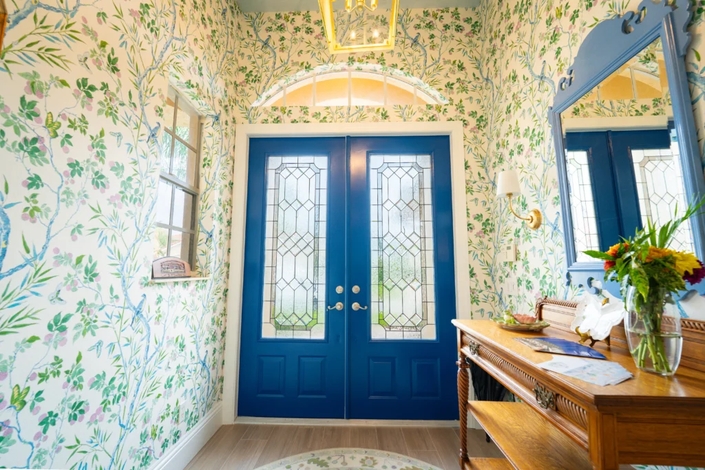 Remodeled foyer with botanical wallpaper and blue leaded-glass double doors by Stuart Kitchen Bath and Flooring