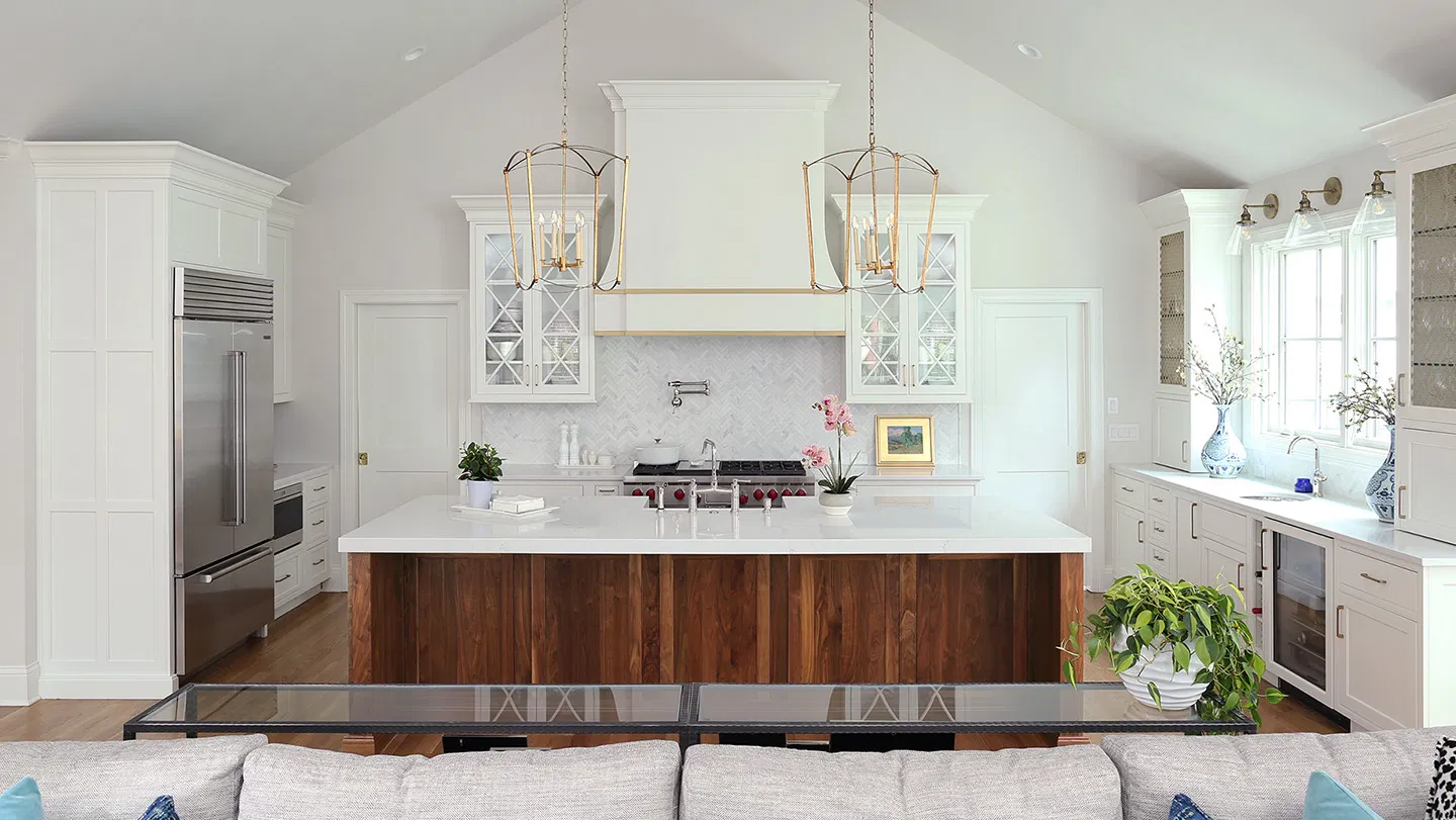White kitchen remodel with a walnut island and marble herringbone backsplash by Stuart Kitchen Bath and Flooring