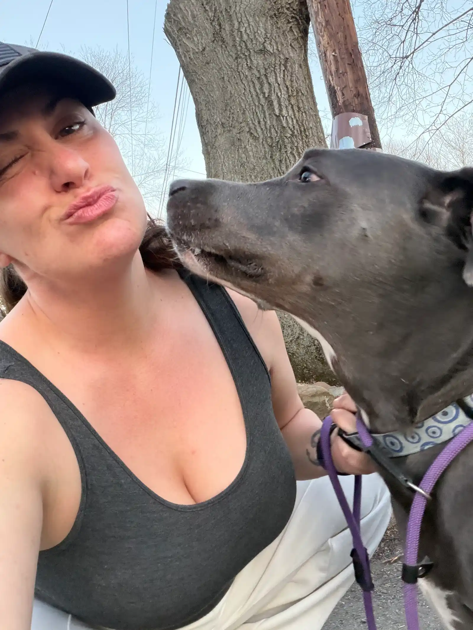 Fun sunny selfie kissing grey dog with purple leash outdoors — Super Gigi pet sitting and dog walking in Bergen County, NJ