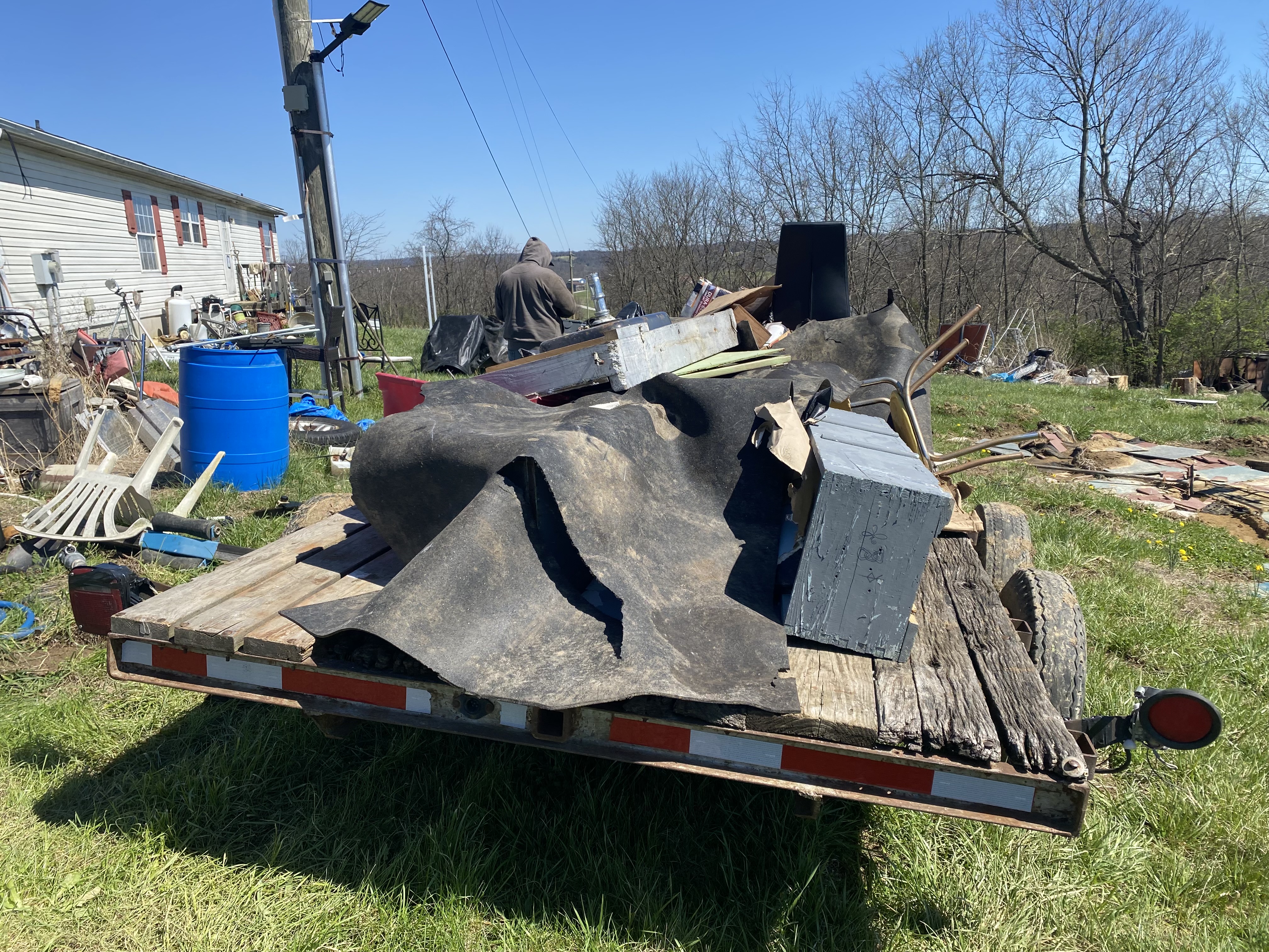 Excavator clearing dense brush and root systems on residential acreage