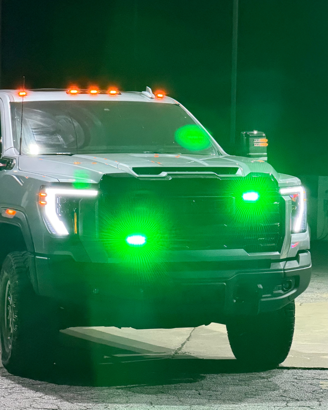 Heavy-duty truck with custom green and amber warning lights mounted on grille and cab