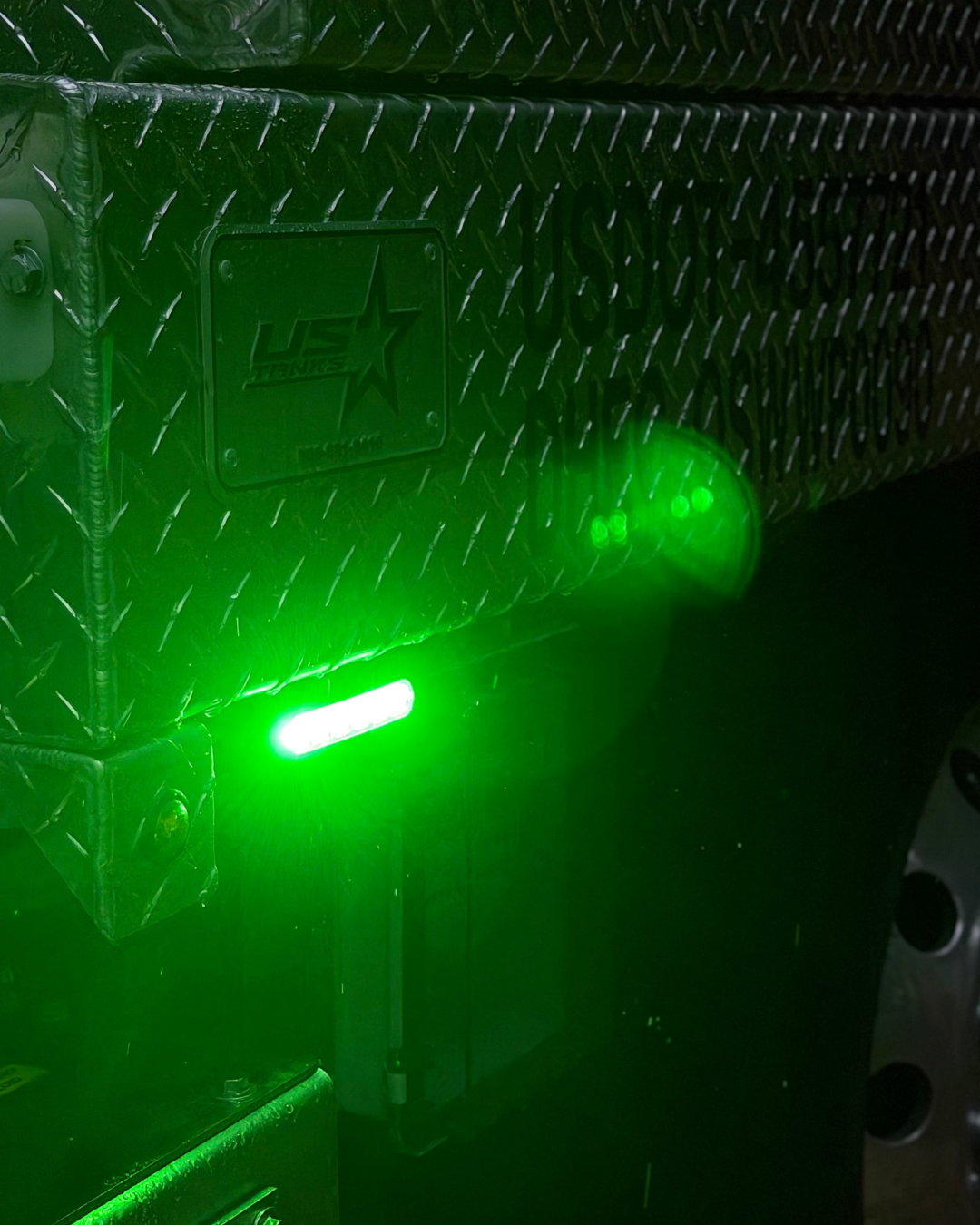 High-intensity green warning strobe mounted to diamond-plate truck box