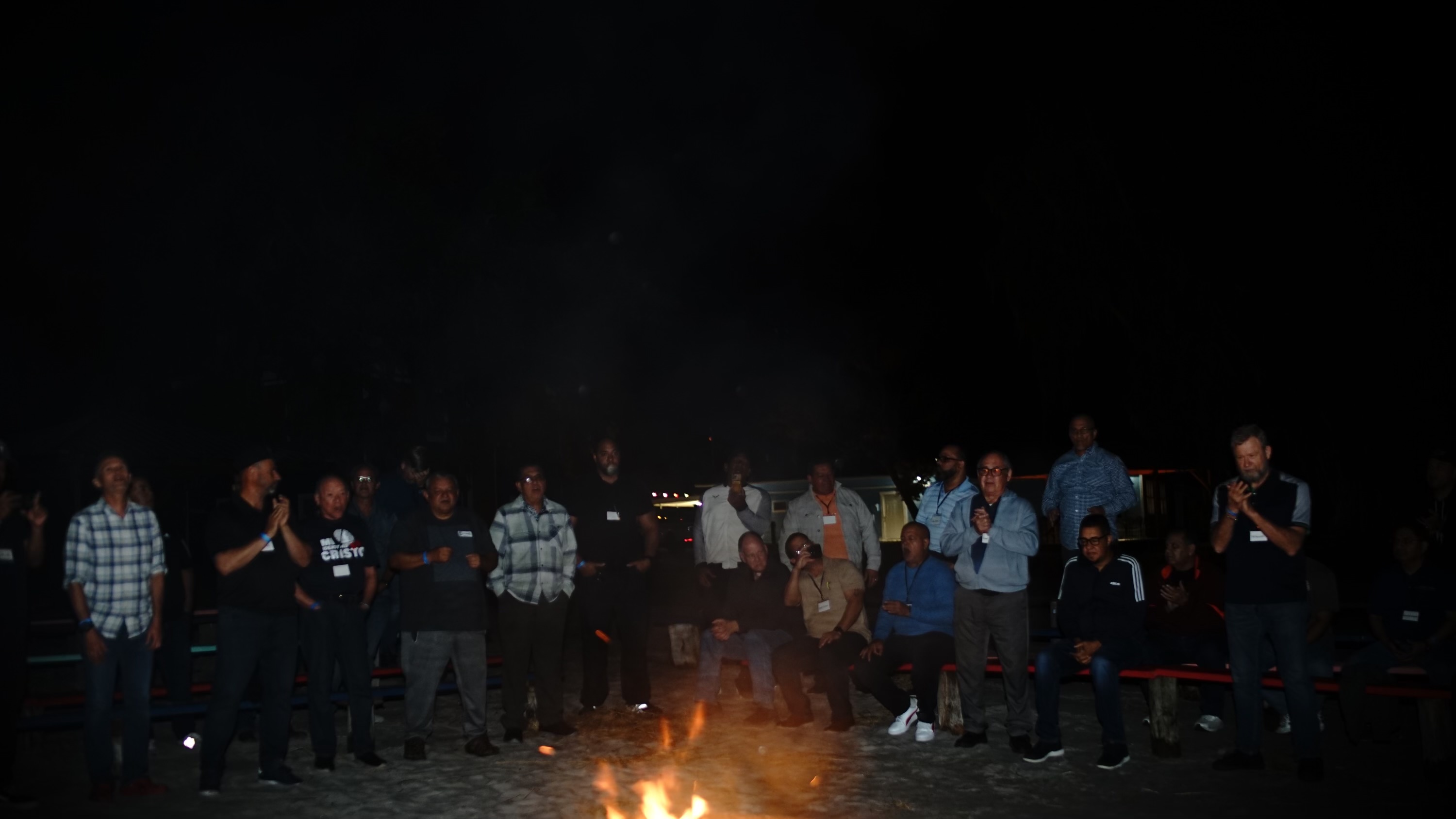 Night campfire group prayer at the Consecration Prayer Summit