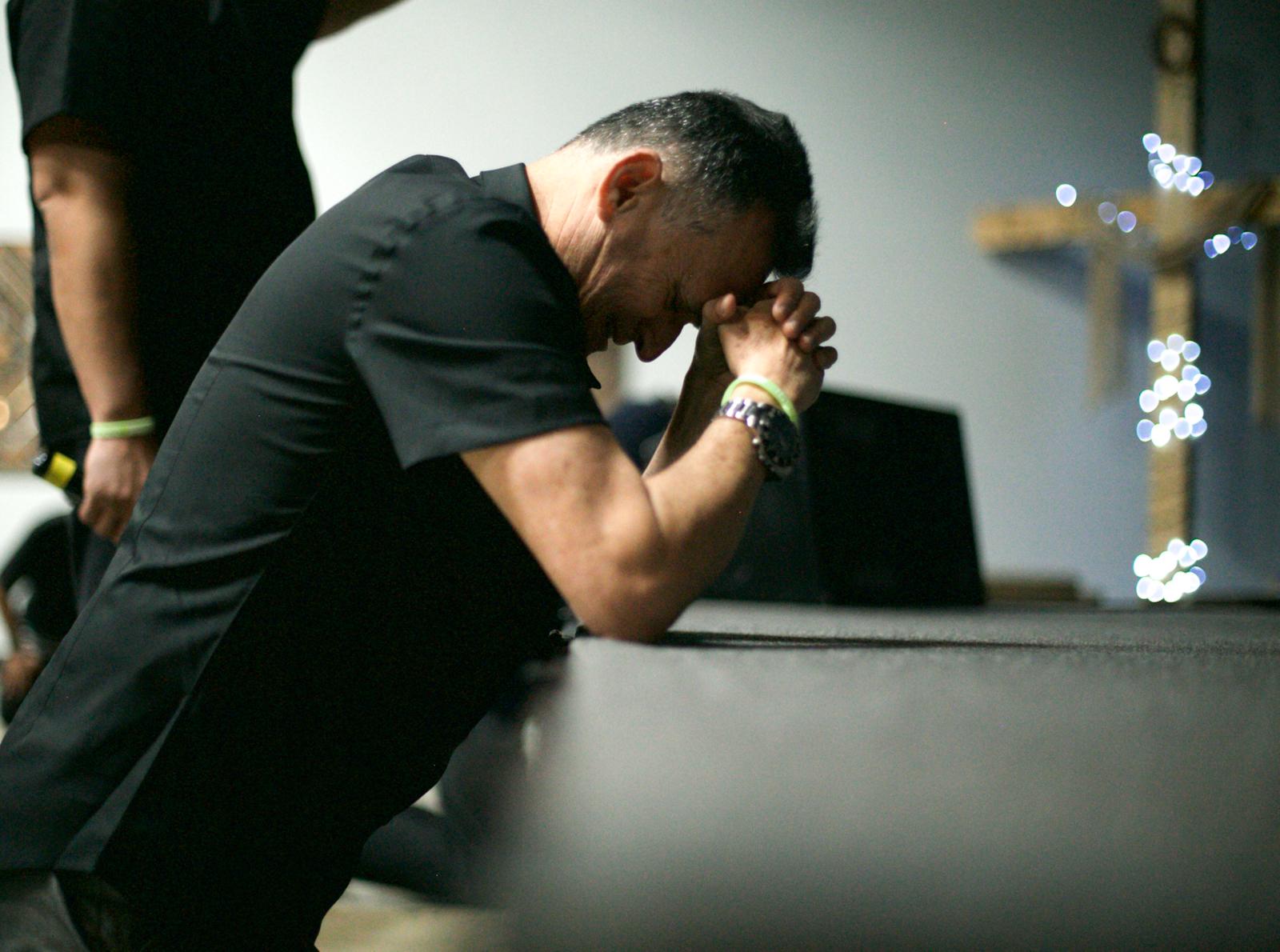 Leader praying at the altar during Recharge