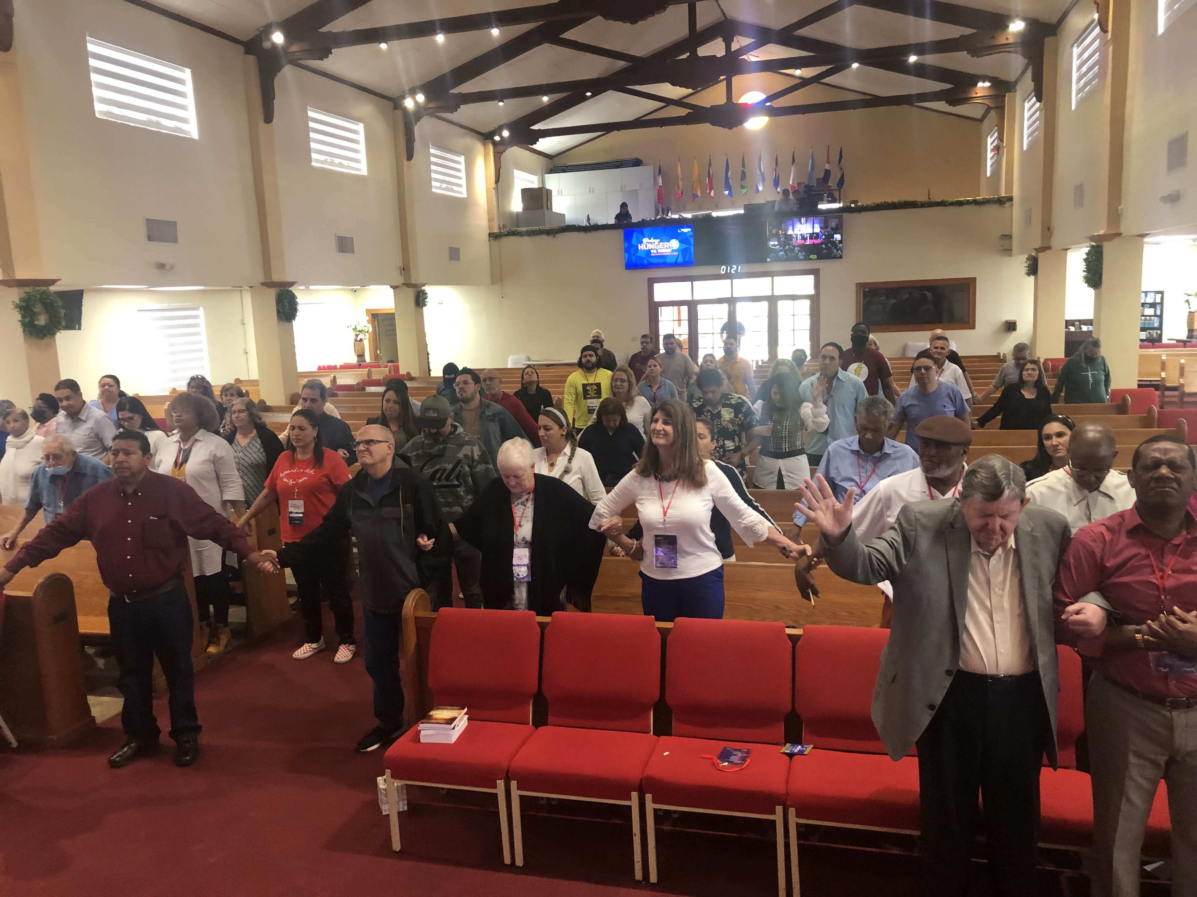 Sanctuary gathered together in prayer across the aisles at Recharge