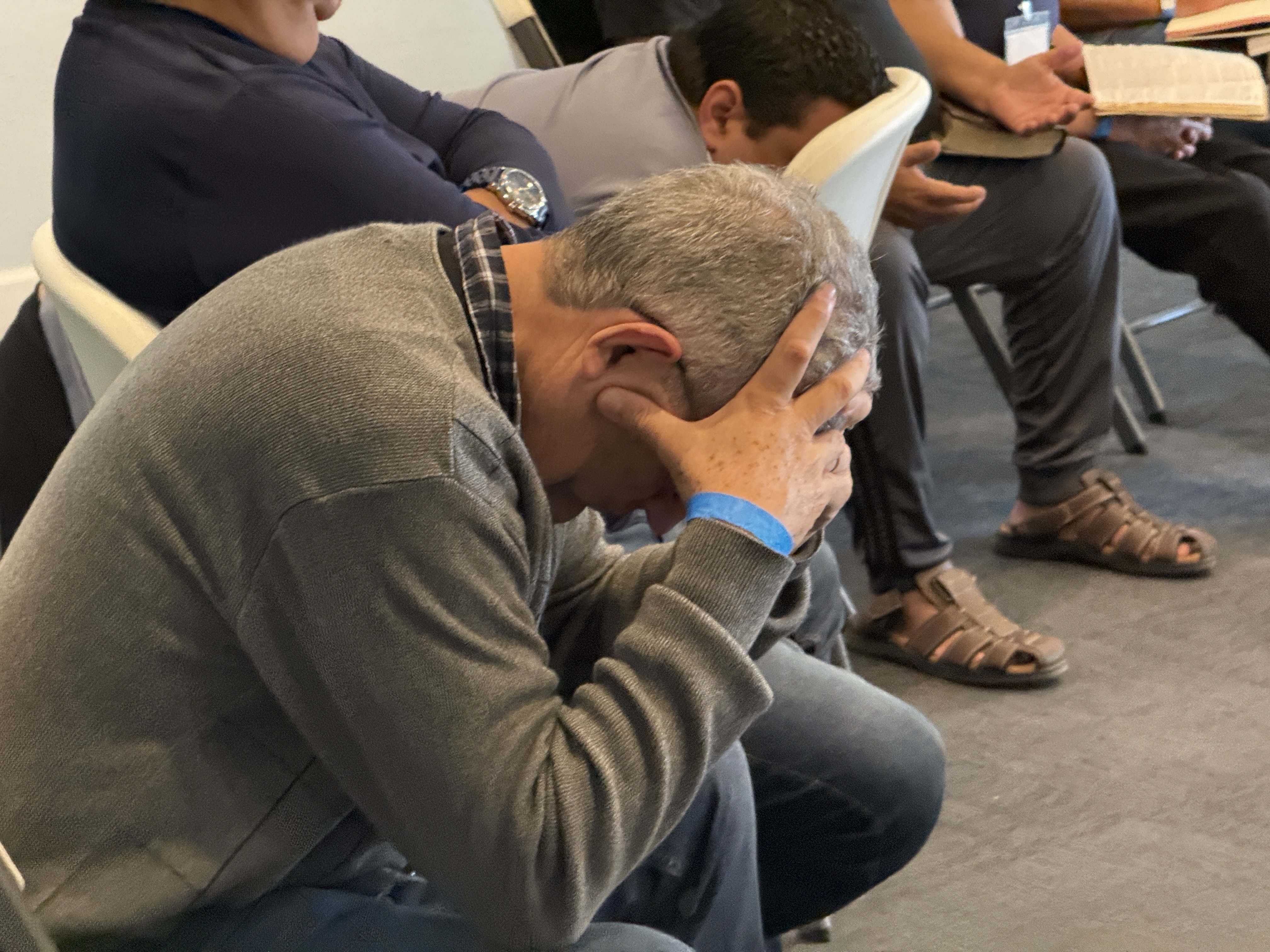 Close-up of a leader praying at the Consecration Prayer Summit