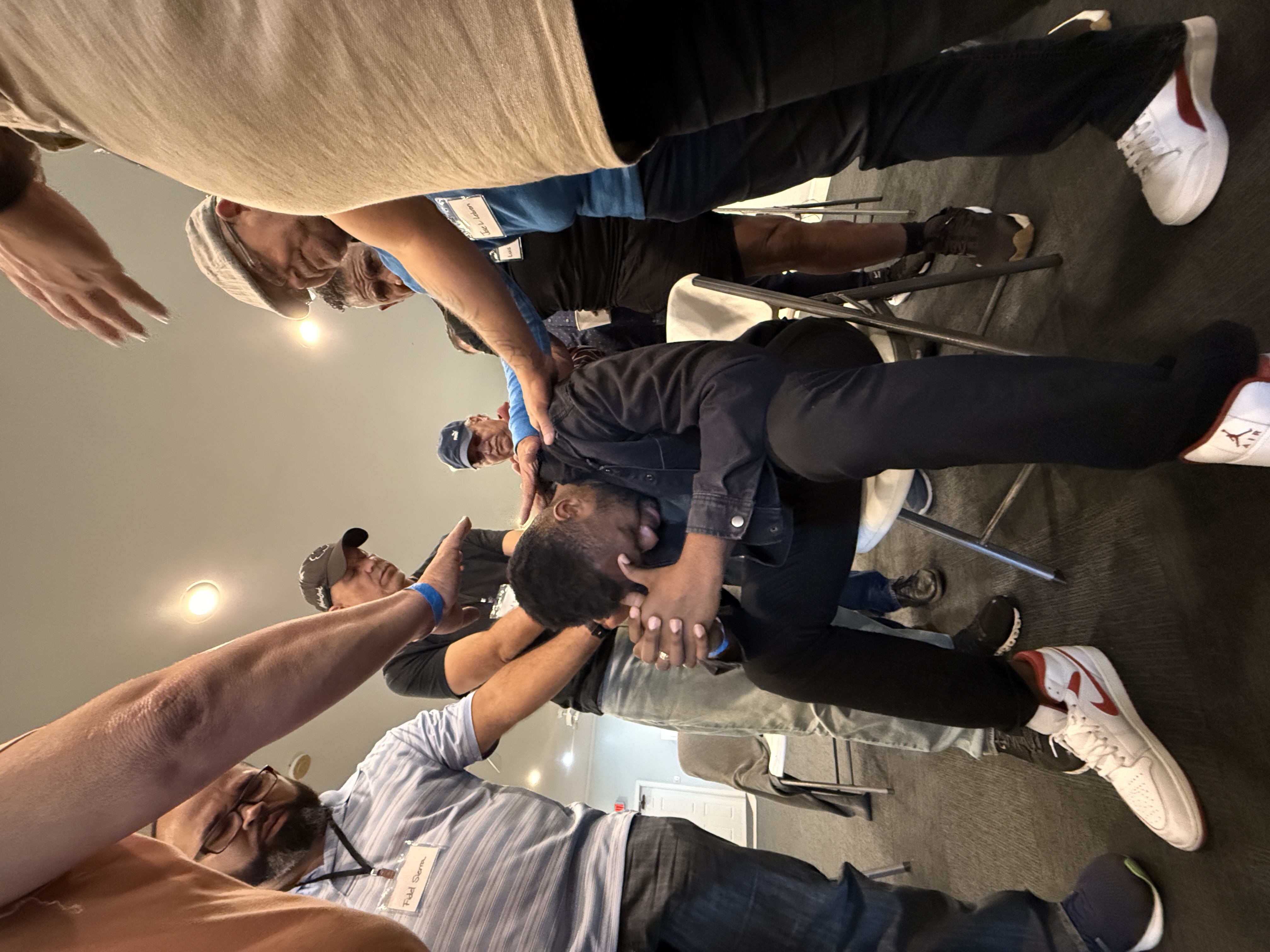 Laying hands on a seated man in prayer