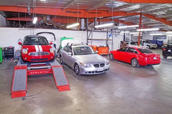 Active collision repair shop floor with hydraulic lifts and certified technicians