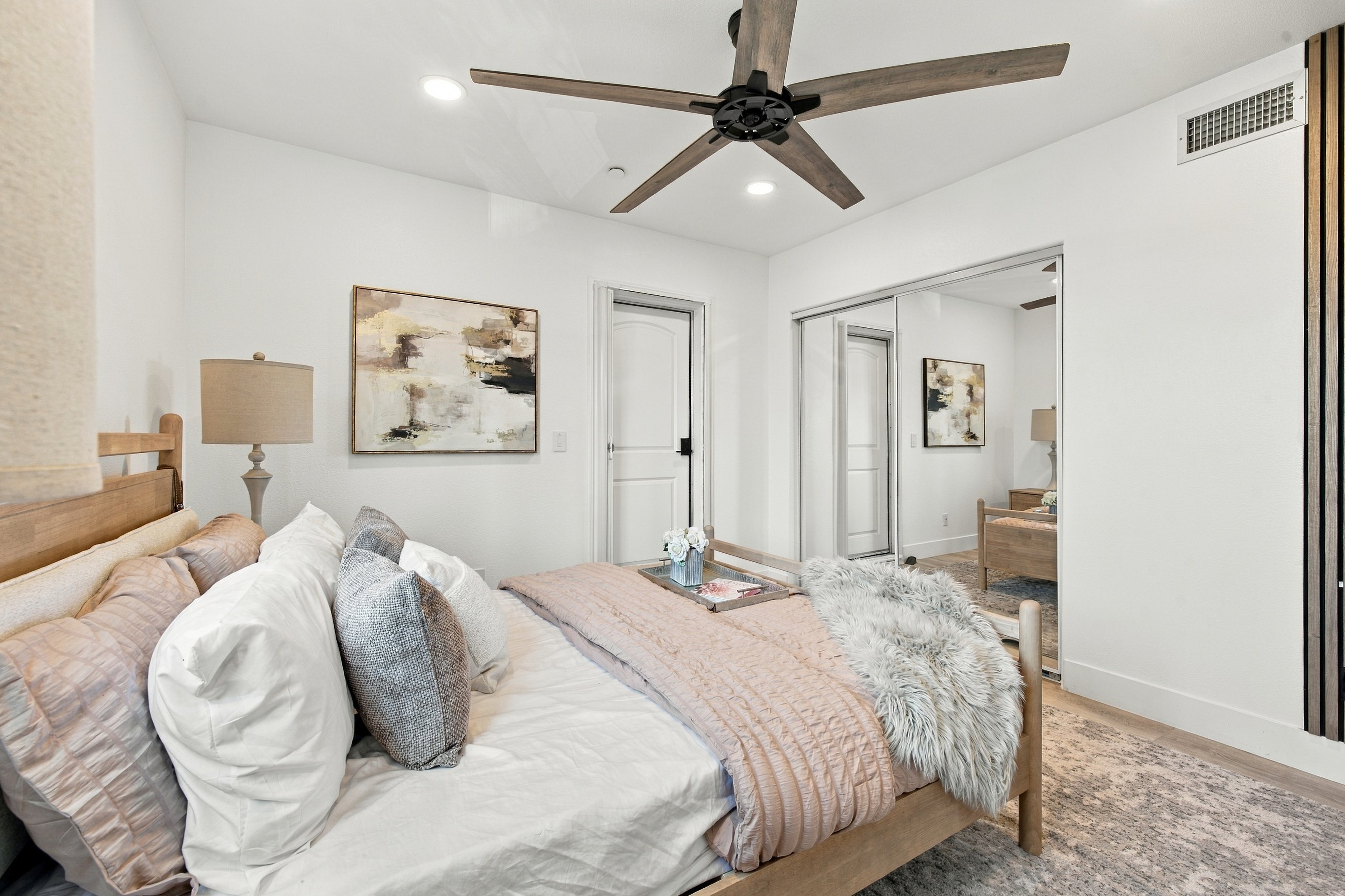 Second bedroom with mirrored closet doors and contemporary finishes