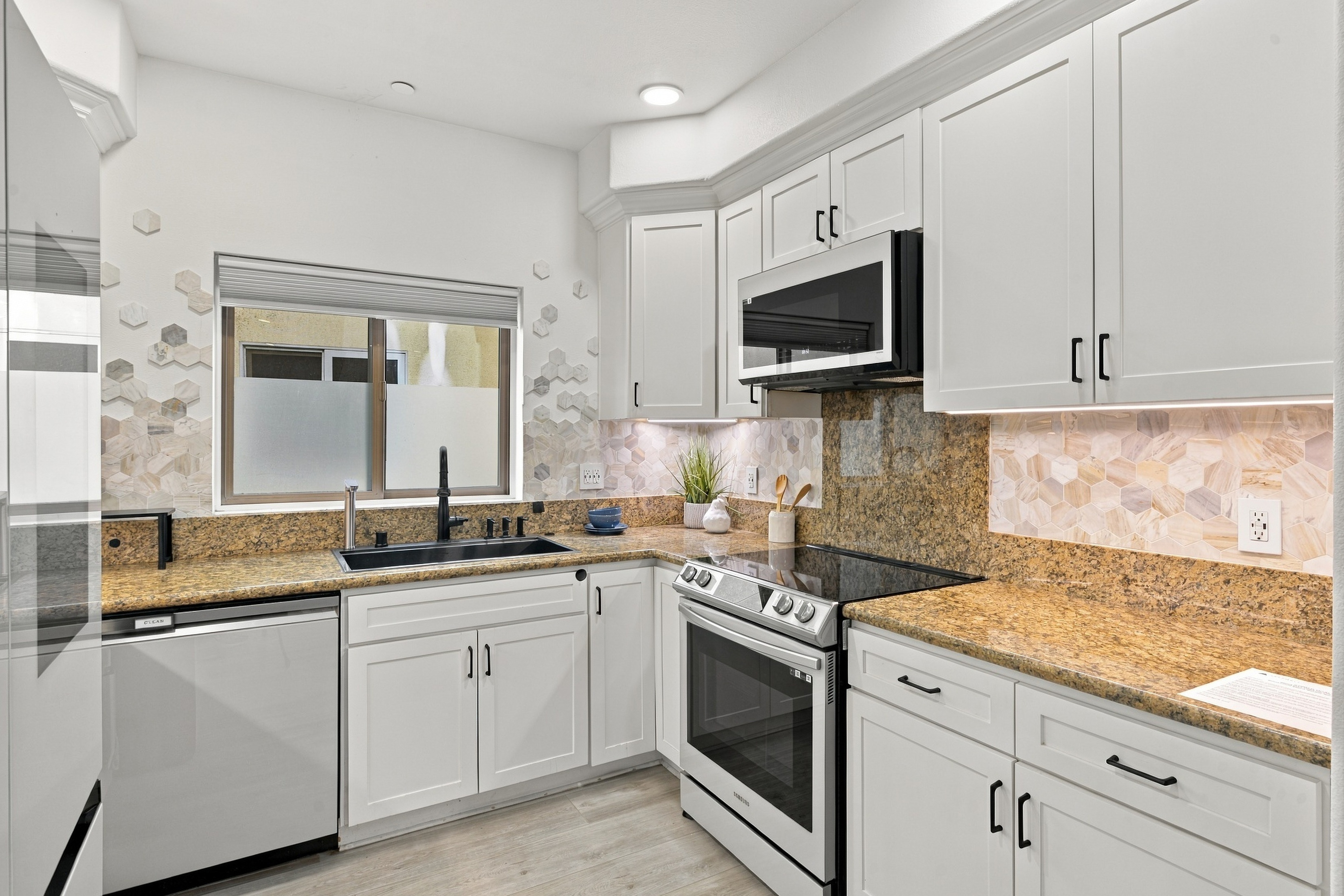 Kitchen details featuring stainless steel range, microwave, and backsplash