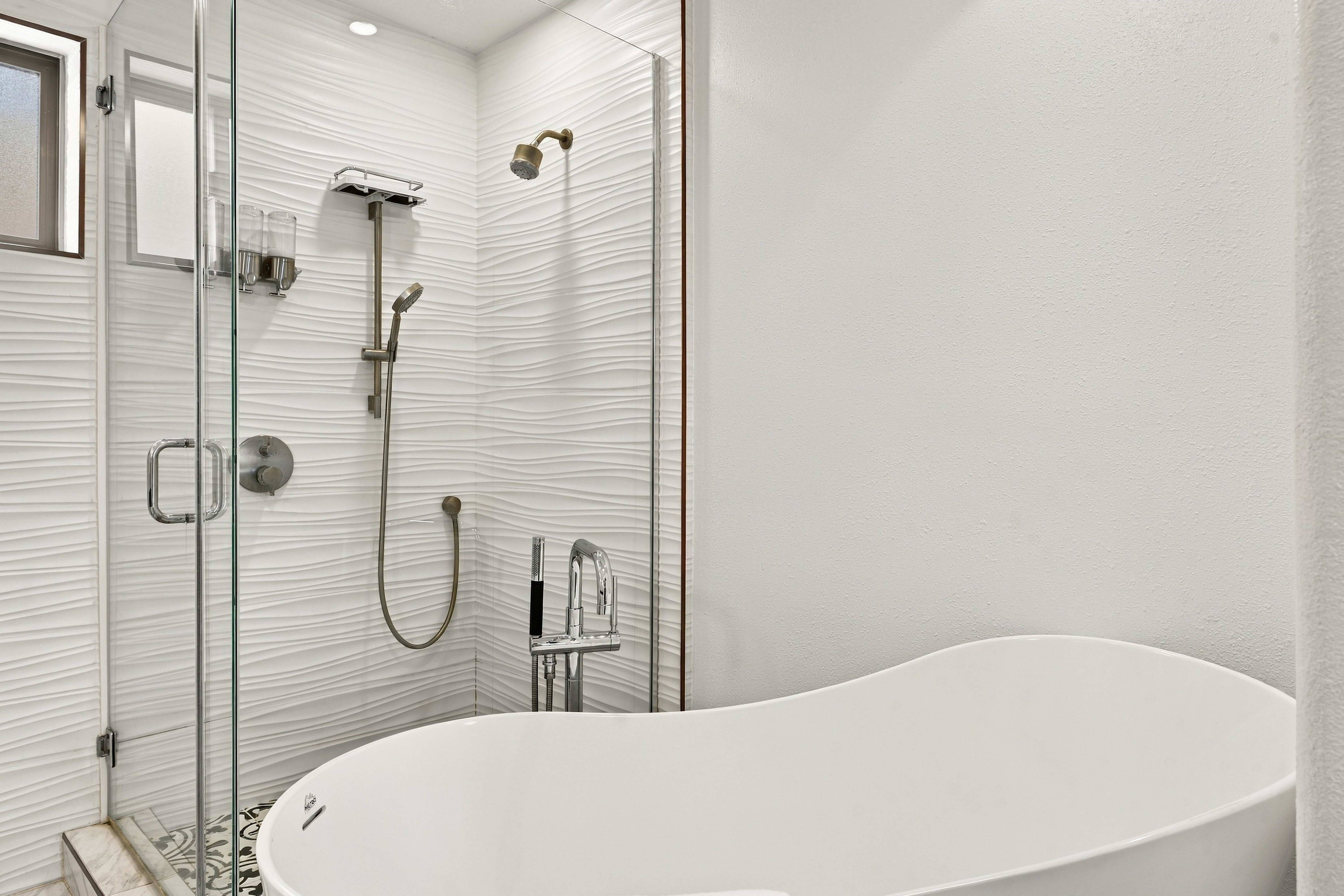 Freestanding soaking tub and walk-in shower with designer fixtures