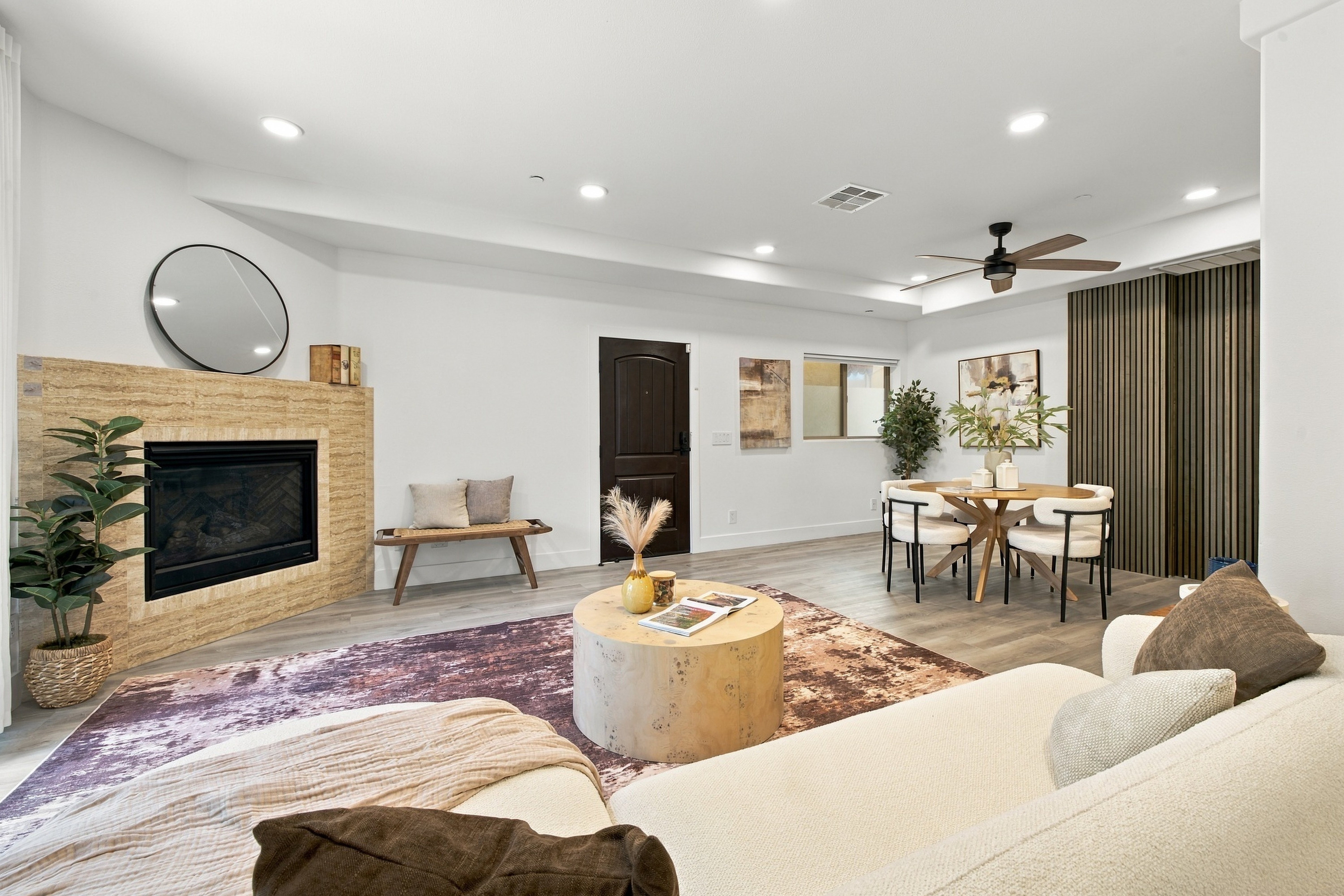 Open-concept living and dining area with designer wood slat accent wall