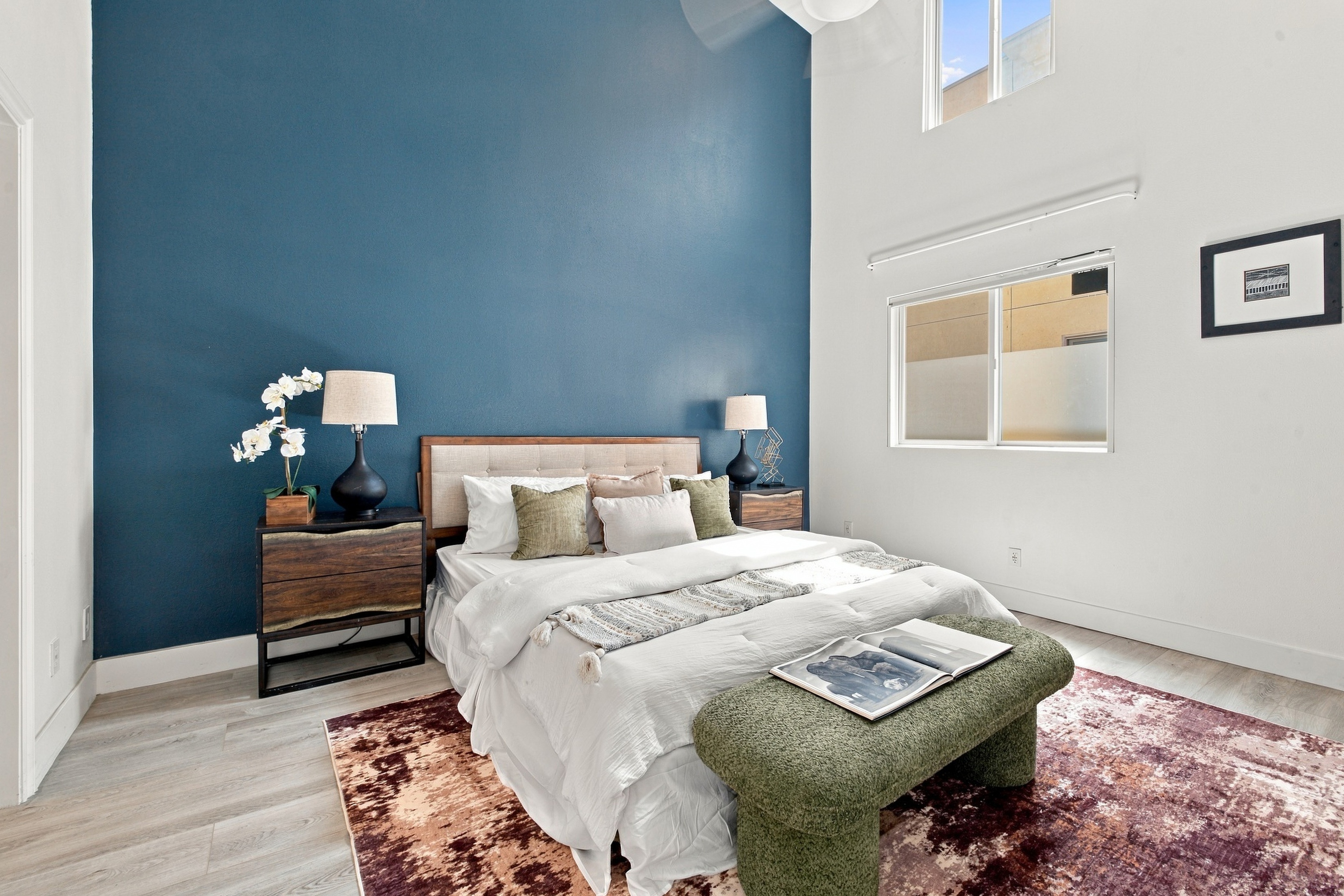 Primary bedroom suite with soaring high ceilings and teal accent wall