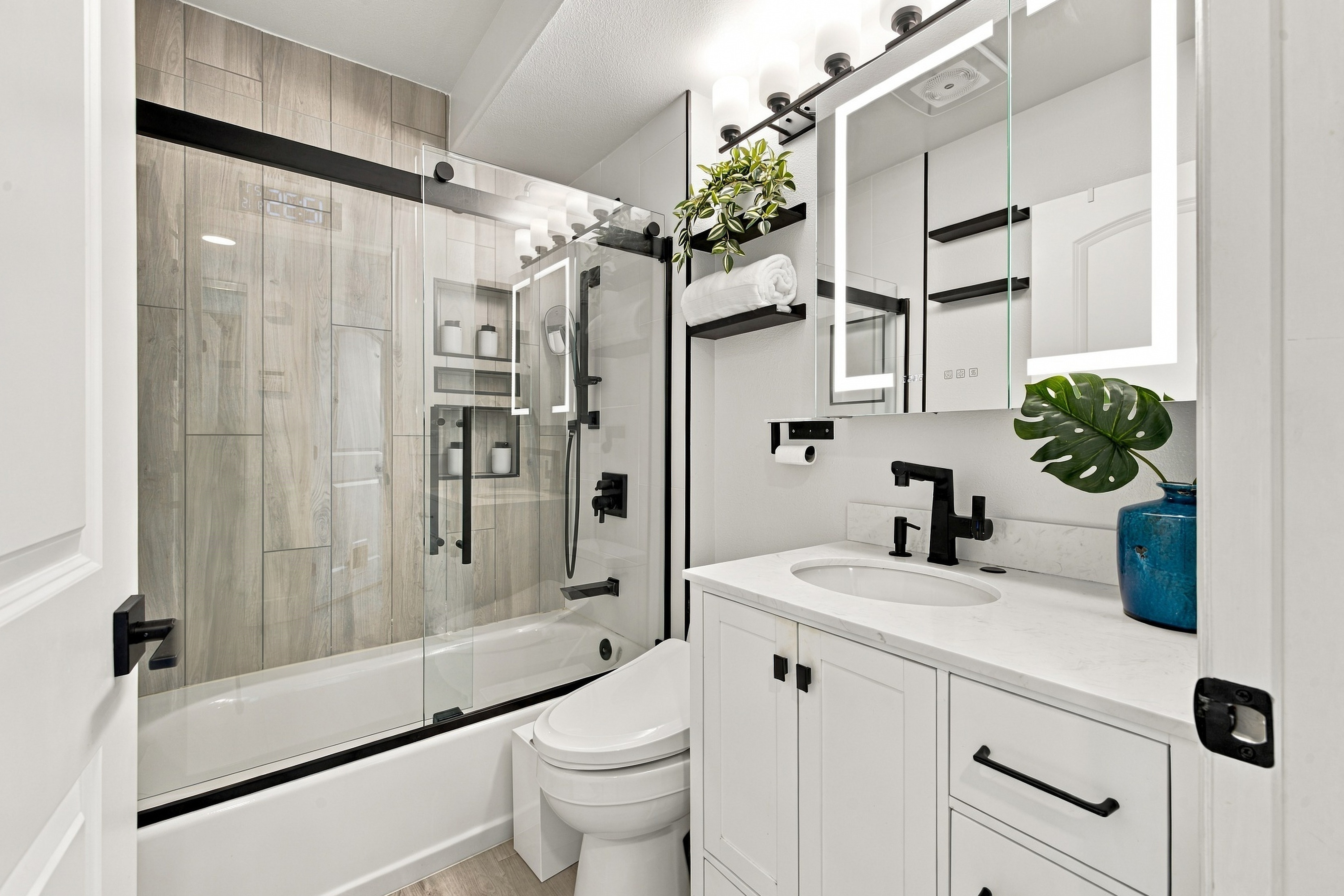 Modern bathroom with frameless glass shower and backlit LED mirror