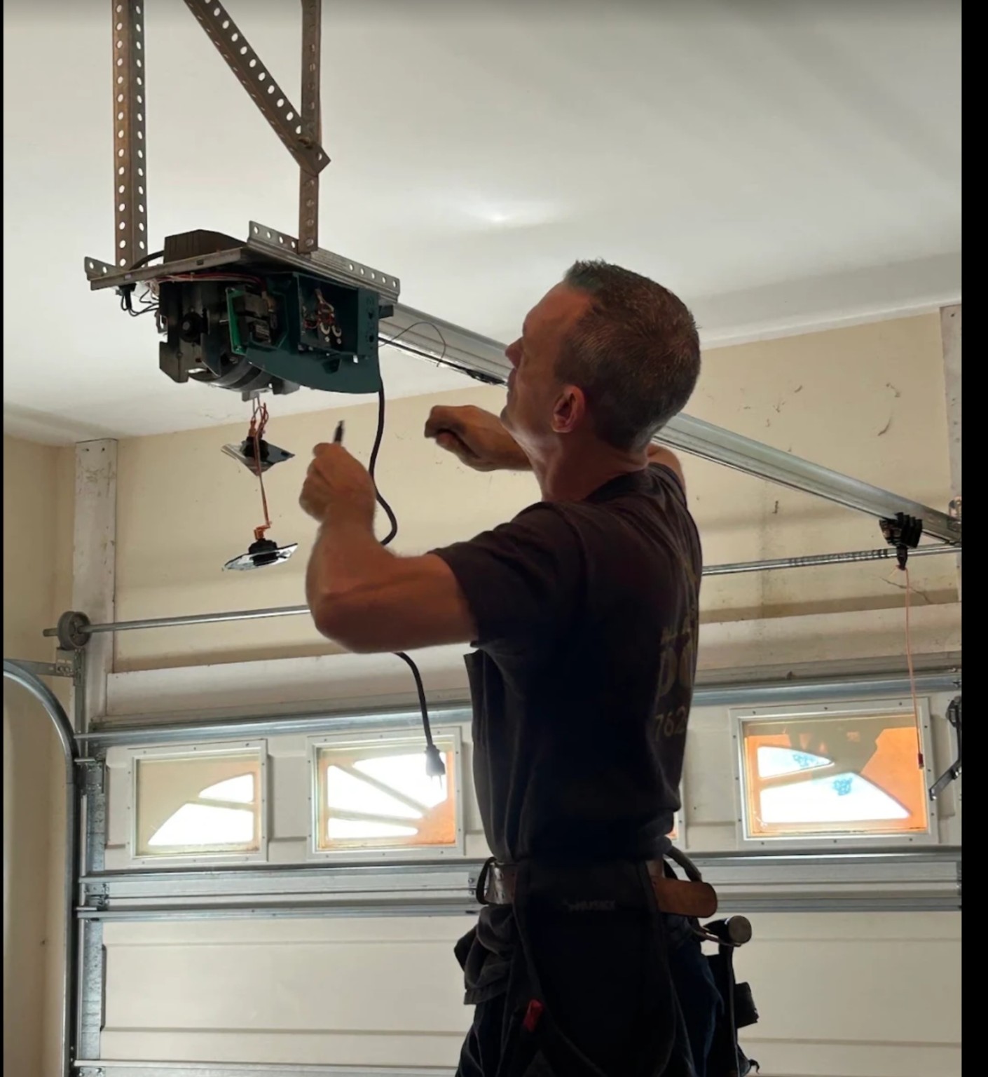 All Access Garage Doors technician working on garage door tracks, cables, and hardware in Thomaston, GA