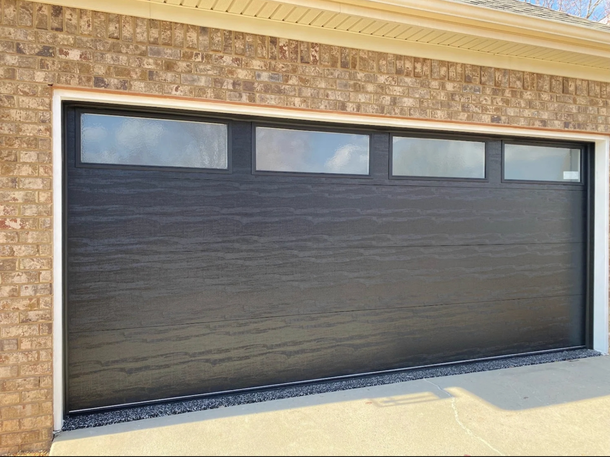 New modern dark garage door installation by All Access Garage Doors on a residential brick home in Georgia
