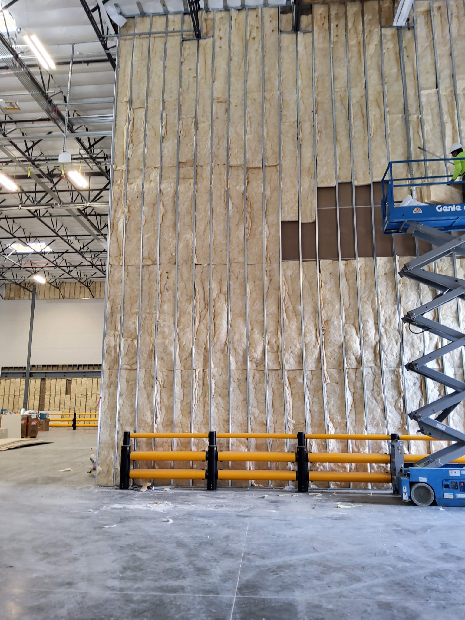 Insulation installation with commercial wall batt insulation and scissor lift