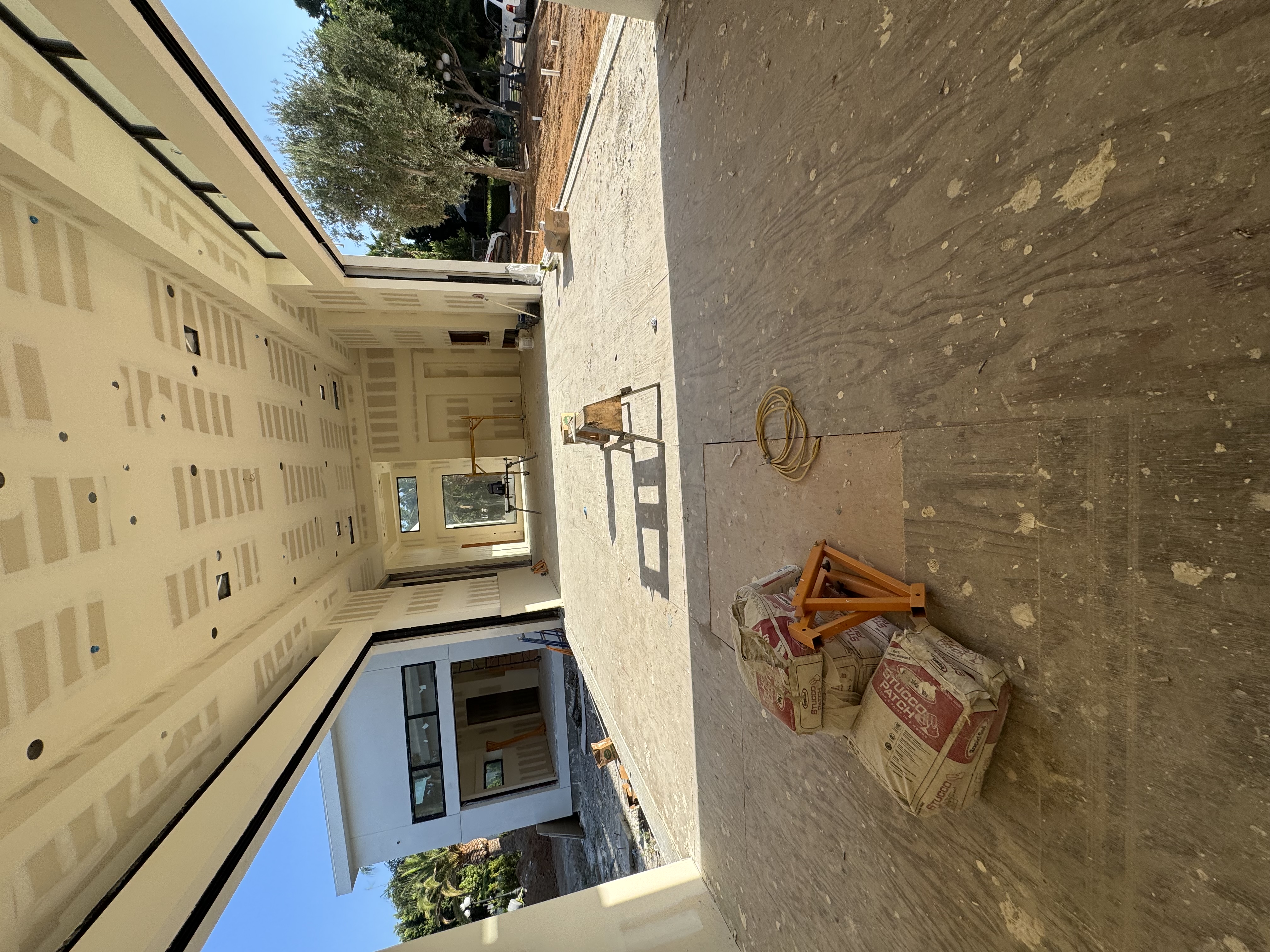 High-ceiling architectural drywall framing and taping installation with expansive covered patio