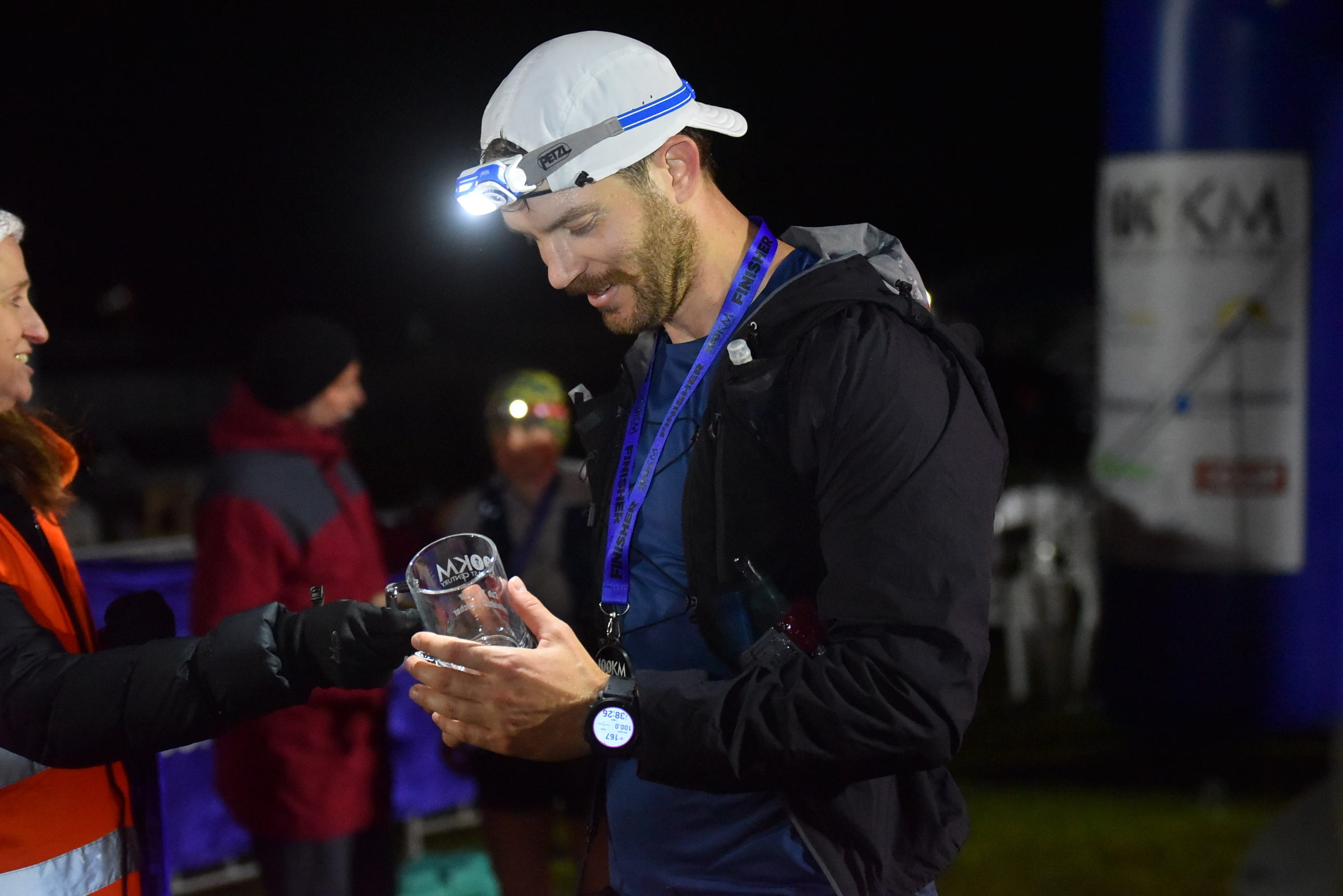 Shard Malchow running at night under headlamp with finisher ribbon