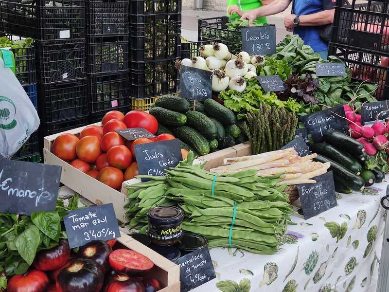Puesto de verduras con tomate mar azul, judía verde y hortalizas