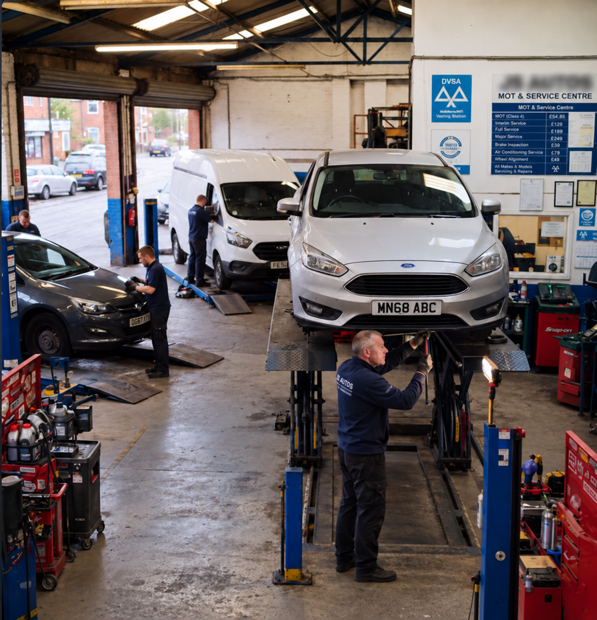 Busy independent UK automotive workshop with multiple ramps, vehicles and technicians working during a normal working day