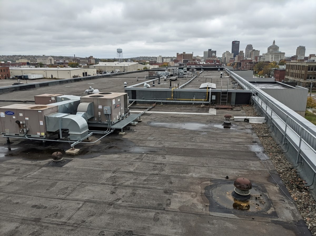 Commercial low-slope flat roof with rubber membrane and roof drains in Syracuse