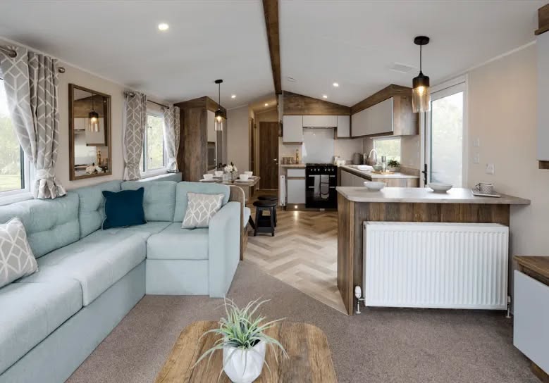 Bright open-plan lodge lounge with corner sofa and breakfast bar