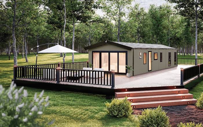 Modern luxury lodge exterior with extensive sun decking and parasol