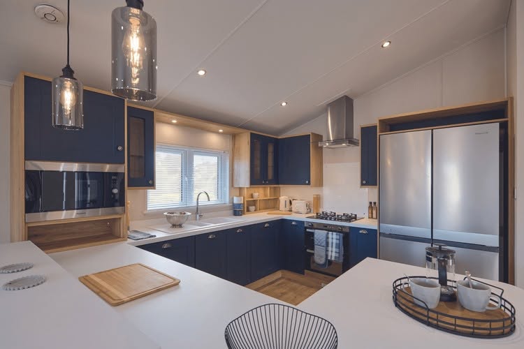 Spacious fitted navy kitchen with island and integrated appliances