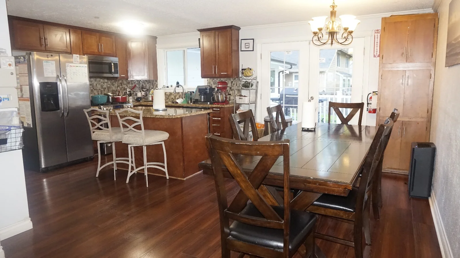 Avenue Home spacious kitchen and communal dining table with hardwood flooring and patio access