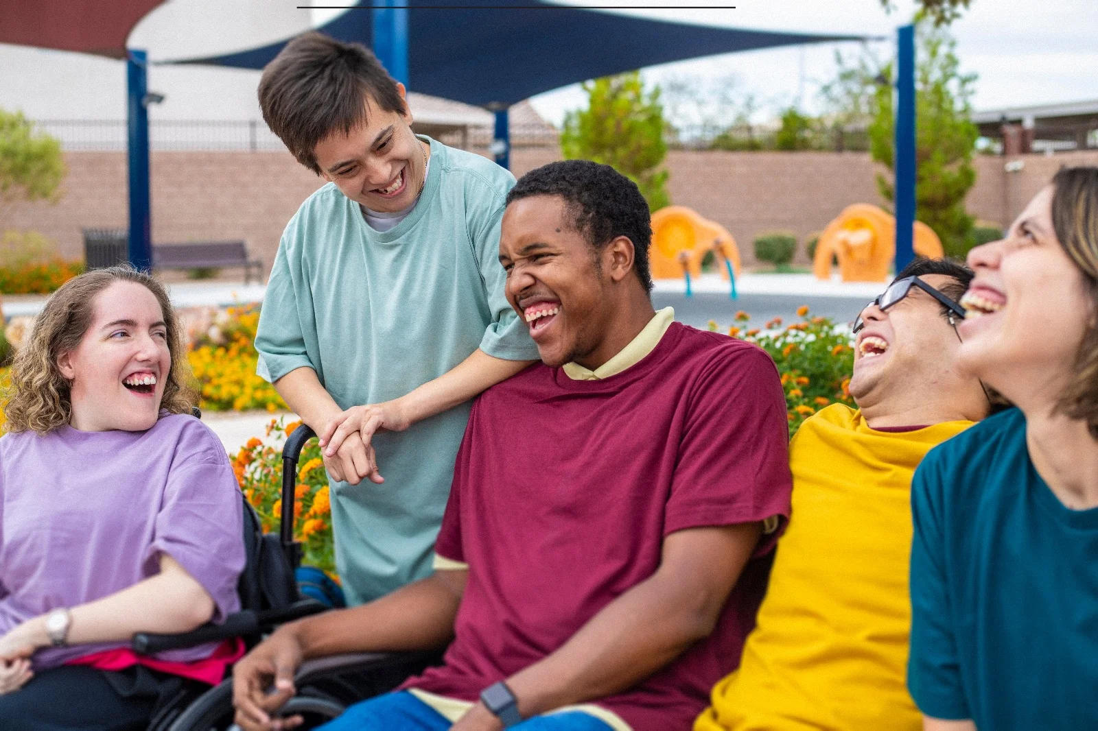 A group of diverse smiling friends laughing together outdoors during a community recreation outing